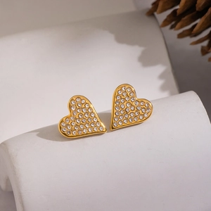 Macro shot of gold-plated heart stud earrings with sparkling pavé crystals