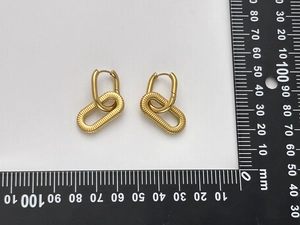 Dettaglio degli orecchini geometrici dorati da 35 mm con righello per la misura