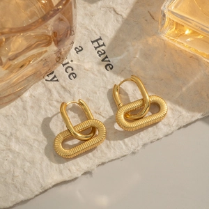 Dettaglio di orecchini a cerchio placcati oro 18K con spirale testurizzata e anello liscio