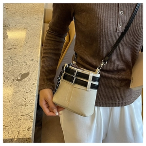 Détail du sac seau beige avec boucles noires et fermeture par cordon tressé