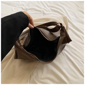 Detail view of the spacious dark brown soft leather tote bag with retro gold zipper