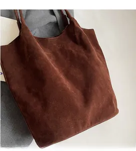 Detailed macro view of soft dark brown suede fabric texture on a minimalist tote bag