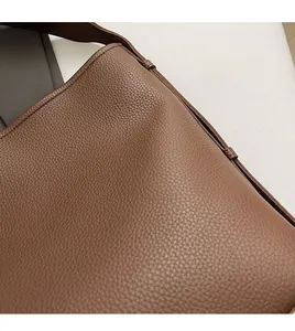Close-up of brown faux leather texture with lychee grain and fine stitching details
