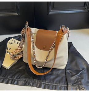 Detail of canvas tote bag with brown leather flap and three interchangeable straps