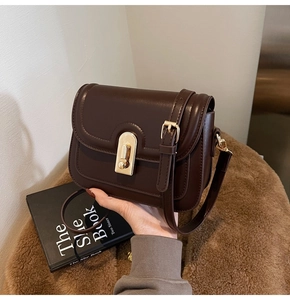 Détail d'un sac à bandoulière vintage marron foncé en cuir mat avec fermoir doré