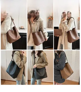 Detail view of minimalist leather bucket bag in black and coffee brown with wide strap