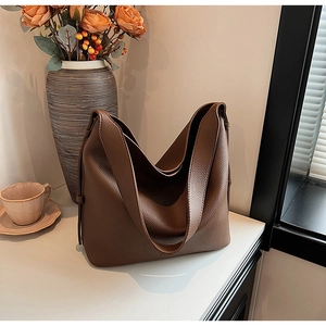 Close-up of brown lychee grain leather tote bag showing soft texture and premium stitching
