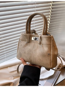 Beige faux leather trapezoid handbag with vintage contrast stitching and rivets