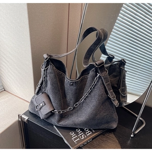 Détail du sac hobo en denim délavé avec chaîne en métal et petite pochette amovible