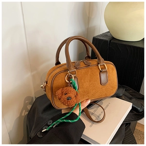 Vue détaillée du sac en daim marron avec breloque ours en peluche et cordon tressé décoratif