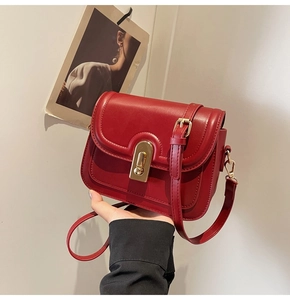Gros plan détaillé d'un sac besace rouge vintage avec une boucle dorée élégante