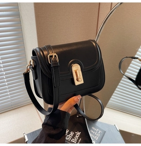 Détail du sac à bandoulière noir avec texture en cuir mat et fermoir en métal doré chic
