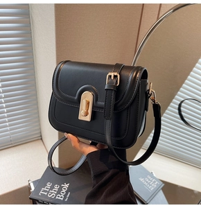 Vue détaillée d'un petit sac carré noir avec boucle rectangulaire dorée sophistiquée