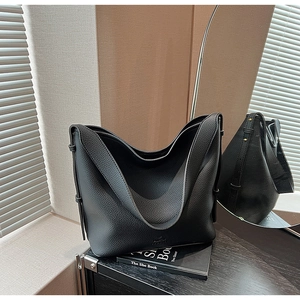 Close-up of black lychee grain leather hobo bag featuring wide strap and fashion embossed logo