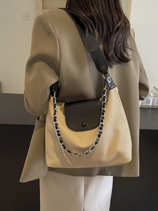 Chic beige textured hobo tote bag with black leather strap on a professional model