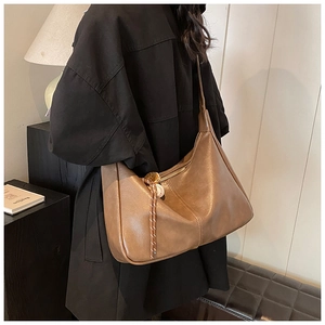 Close-up of brown vintage hobo bag with braided rope and wooden bead zipper detail