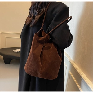 Detail of minimalist dark brown matte PU leather tote bag with elegant draped texture