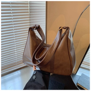 Detail of dark brown leather hobo bag with a wide strap and smooth matte finish