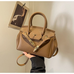 Detailed view of the brown lychee pattern leather bag with gold hardware and top handle