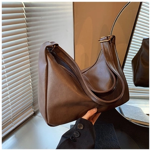 Detailed view of dark brown leather hobo bag showing matte texture and crescent shape