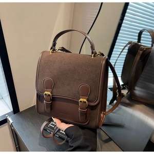 Detail of vintage coffee brown backpack with dual buckles and smooth suede texture