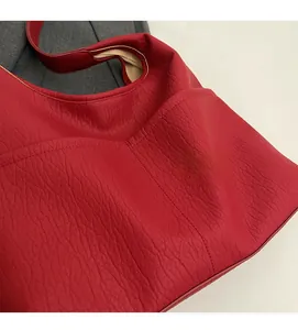 Close-up of red PU leather tote bag with litchi texture and soft brown lining
