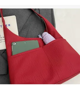 Macro view of red lychee grain leather tote bag showing spacious inner pocket capacity