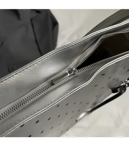 Detail of silver tote bag with smooth metal zipper and stylish polka dot perforated texture