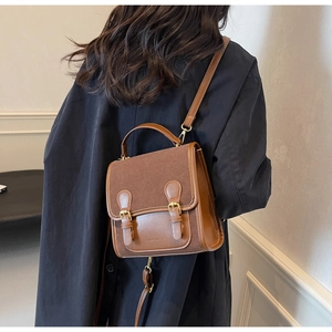 Detail of retro brown leather shoulder bag with buckle straps and stylish mixed textures