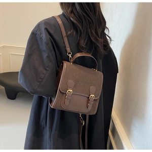 Detail of vintage brown shoulder bag with double buckles and textured leather patchwork