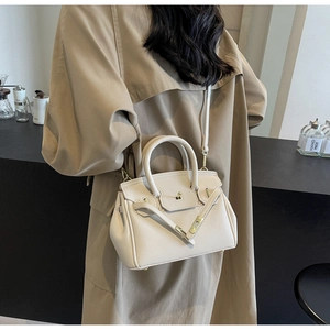 Detailed macro view of the beige lychee pattern leather bag with gold metal hardware
