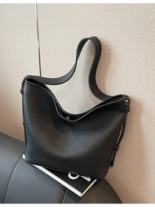 Retro black lychee leather hobo bucket bag with adjustable wide strap shown in lifestyle setting