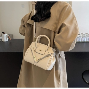 Beige textured leather satchel worn over a khaki trench coat to show size and style