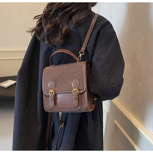 Detail view of vintage brown satchel with gold buckles and suede-leather texture