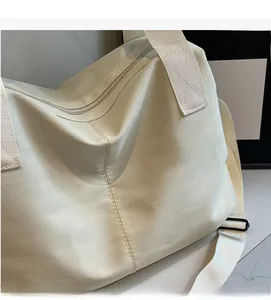 Detail of soft cream quilted nylon fabric and silver zipper on the large tote bag
