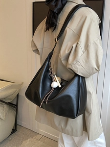 Classic black matte Hobo shoulder bag with baseball pendant charm shown on a model