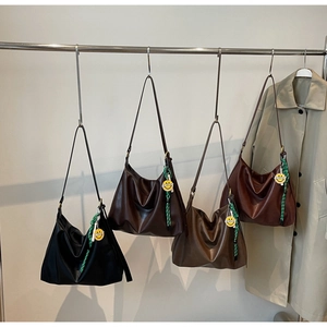 Détail de grands sacs hobo en quatre couleurs rétro avec breloques sourire