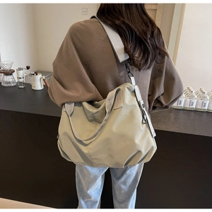 Close-up of lightweight sage green tote bag with wide grey strap for daily commute