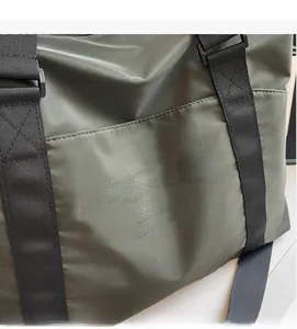 Close-up of army green travel bag showing high-density woven fabric and Come Know text