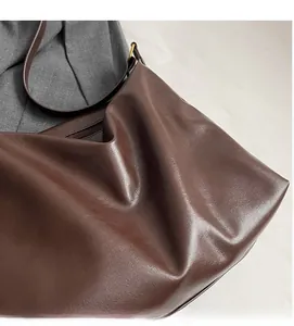 Détail du grand sac cabas marron foncé montrant le cuir souple et la boucle en métal