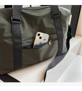Detail of exterior zipper pocket on olive green travel bag showing smartphone storage