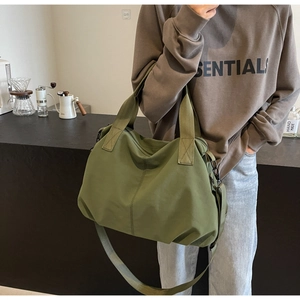 Olive green tote bag with wide shoulder strap and durable metal zipper detail