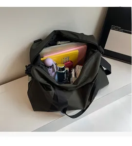 Top view showing large interior capacity of olive green nylon bag with travel essentials