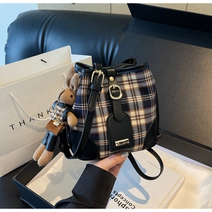 Detail van een geruite emmertas met konijnenhanger in een luxe geschenkverpakking