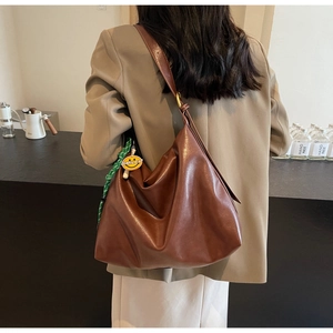 Vue détaillée du dos d'un grand sac hobo en cuir marron avec un pendentif smiley