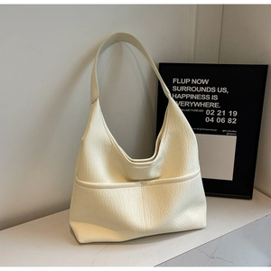Detailed view of the creamy white leather tote bag with functional double front pockets