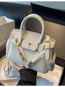 Off-white pebbled leather handbag with gold hardware and removable shoulder strap