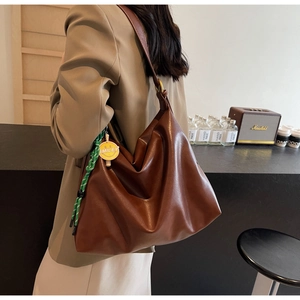Vue détaillée du grand sac cabas marron avec charme smiley porté par un mannequin