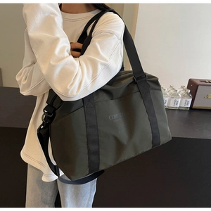 Man carrying a large olive green waterproof sports duffel bag for travel or gym