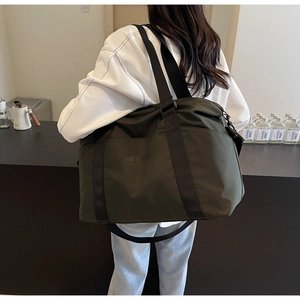 Close-up of army green travel bag featuring durable nylon fabric and wide shoulder strap